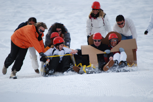 Teamwork beim Kartonschlitten Rennen